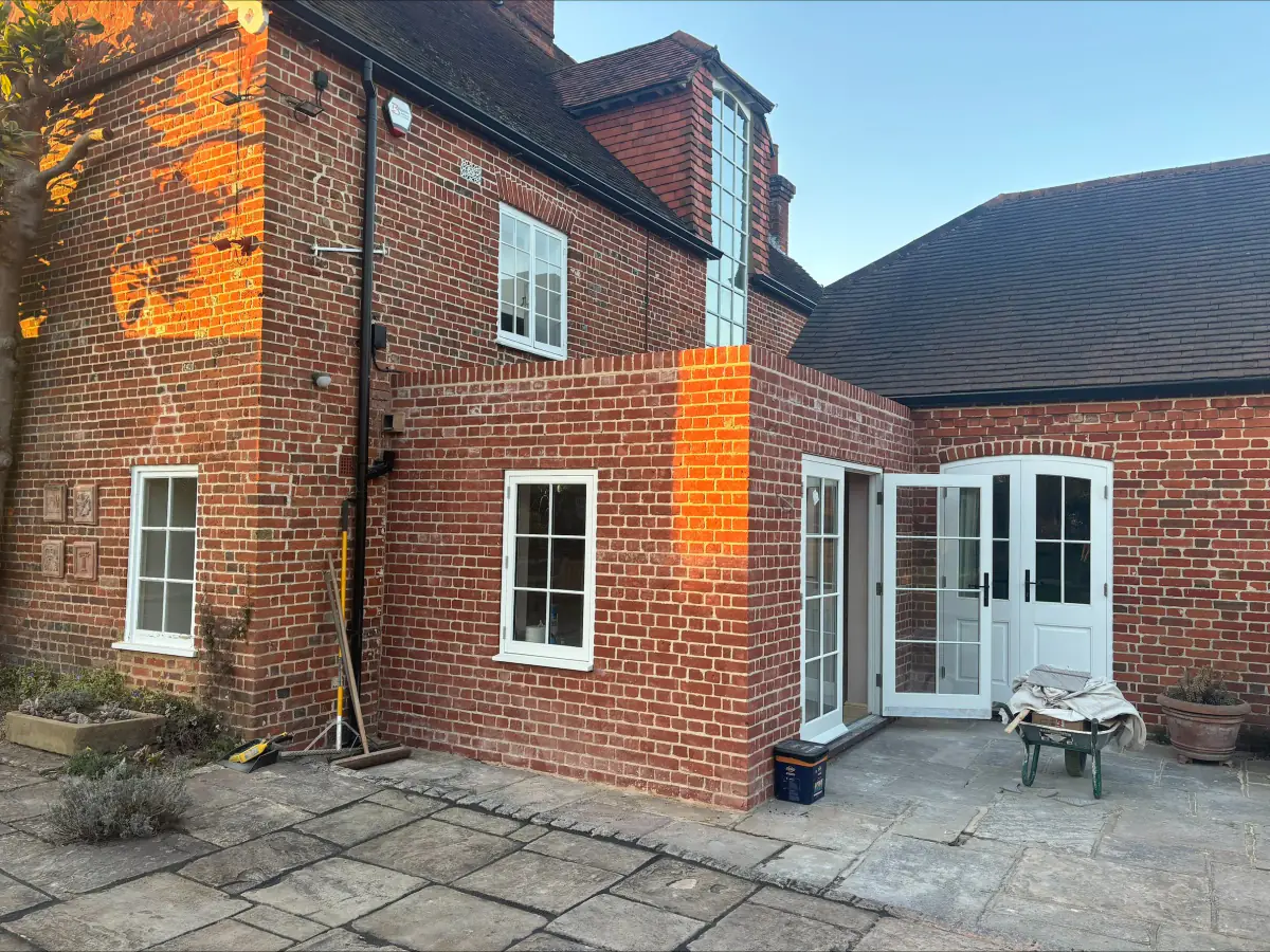 Brick rear kitchen extension with French doors on to a paved terrace
