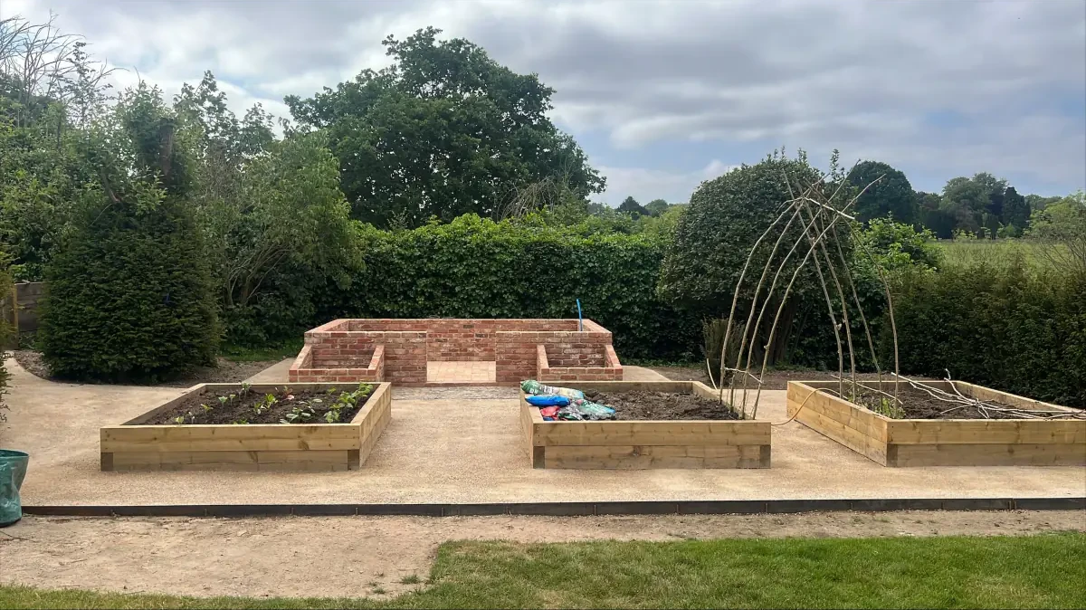 Brick and timber raised beds on a gravel kitchen garden